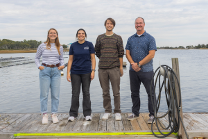 Four members of the PFAS Testing Network stand on a dock.